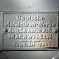 Ein Traditionsunternehmen liefert (am Notausgang zum Postbunker). Die Deutsche Metalltüren-Werke werden 1880 in Hamburg gegründet. 1901 erhält das Unternehmen das kaiserliche Reichspatent für die Fertigung von Metalltüren und ist bereits in dieser Zeit ein wichtiger Lieferant für Staatsbauten. Das Unternehmen wirbt heute (als Teil der Horstmann-Gruppe, Bielefeld): Als Hersteller von Feuerschutztüren und -toren hat dmw schwarze im deutschen Wettbewerb die längste Tradition und darauf aufbauend einen nahezu konkurrenzlosen Produktstandard geschaffen. Die Referenzliste weist die Mitarbeit an Schulen, Parkhäusern oder Banken aus, allein was mit keinem Wort erwähnt wird: In Zeiten des Kalten Krieges hat man prächtig mit der Herstellung von Luftschutztüren verdient, die in zahllosen Bunkern bundesweit verbaut wurden und hat hierbei sicher auch eine Reihe von Erfahrungen sammeln können  bei den Türen wie auch dem Vertrieb.