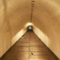 Blick in den ausgeleuchteten Notausgang (Richtung Tunnelknick). Gut zu sehen sind die herausnehmbaren Bodenplatten, unter denen ein Versorgungsschacht liegt (u.a. für die Kommunikationstechnik, so zum Sendemast auf dem Steiner Berg).