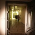 Wieder am Bunkerzugang des Notausganges. Rechts vorne die Tür der Deutsche Metalltüren-Werke, im Bildhintergrund ist rechts die Treppe für den Weg ins Oberschoss zu sehen, ganz am Ende rechts geht es auf den langen Hauptflur Richtung Haupteingang, dort geradeaus in die Netzersatzanlage und den Abluftschacht.